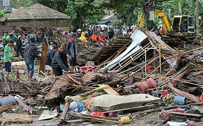 Des résidents inspectent une maison endommagée par un tsunami, à Carita, en Indonésie, le 23 décembre 2018 (AP Photo)