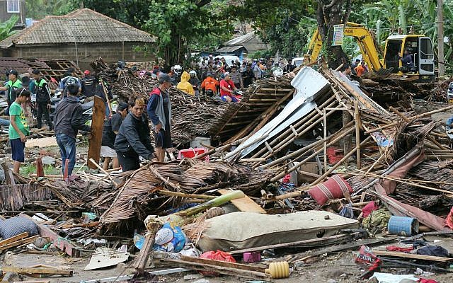 Des résidents inspectent une maison endommagée par un tsunami, à Carita, en Indonésie, le 23 décembre 2018 (AP Photo)