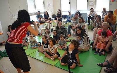 Une bénévole fait chanter des chansons de Hanoukka aux enfants de la garderie "Daycare of Dreams" à Ramat Gan. (Avec l'aimable autorisation de Larger Than Life)