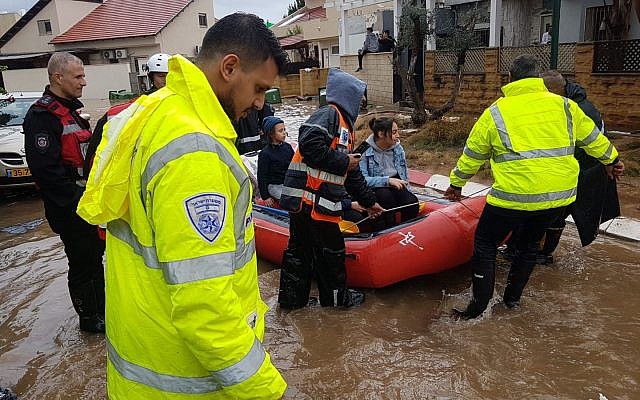 Des sauveteurs évacuent les habitants de Ahiezer de leurs maisons inondées, le 7 décembre 2018. (Crédit : police israélienne)