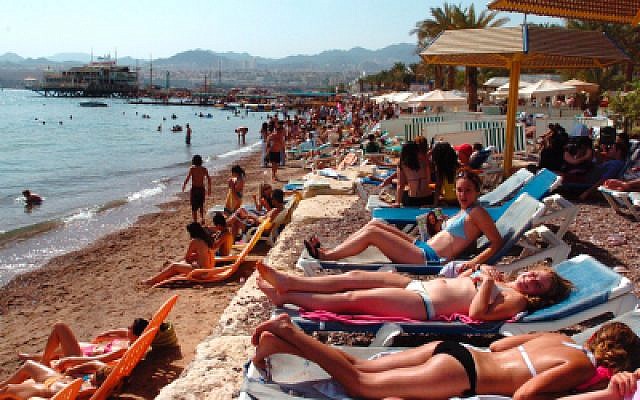 Des touristes et des Israéliens sur la plage d'Eilat. (Crédit : Nati Shohat/Flash90)