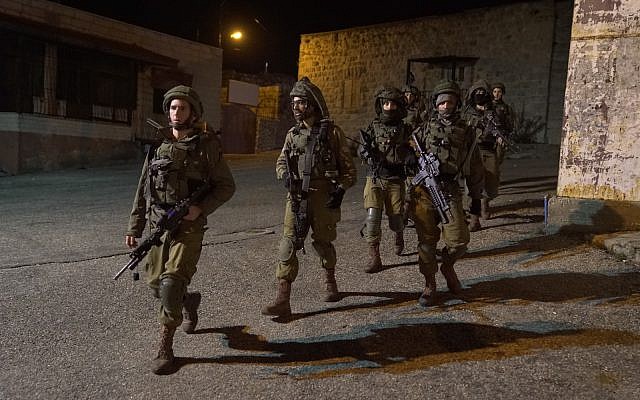Des soldats israéliens recherchent des hommes armés qui ont ouvert le feu sur un arrêt de bus à l'extérieur de l'implantation d'Ofra en Cisjordanie, blessant sept personnes, le 9 décembre 2018. (Armée israélienne)