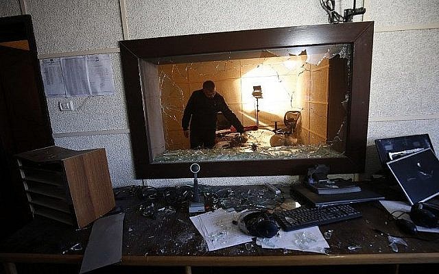 Un employé des stations de radio et de télévision dirigées par l'Autorité palestinienne inspecte les dégâts dans l'un des studios le 4 janvier 2019, après que des hommes armés auraient fait irruption dans le bâtiment de la ville de Gaza. (Crédit : Said Khatib / AFP)