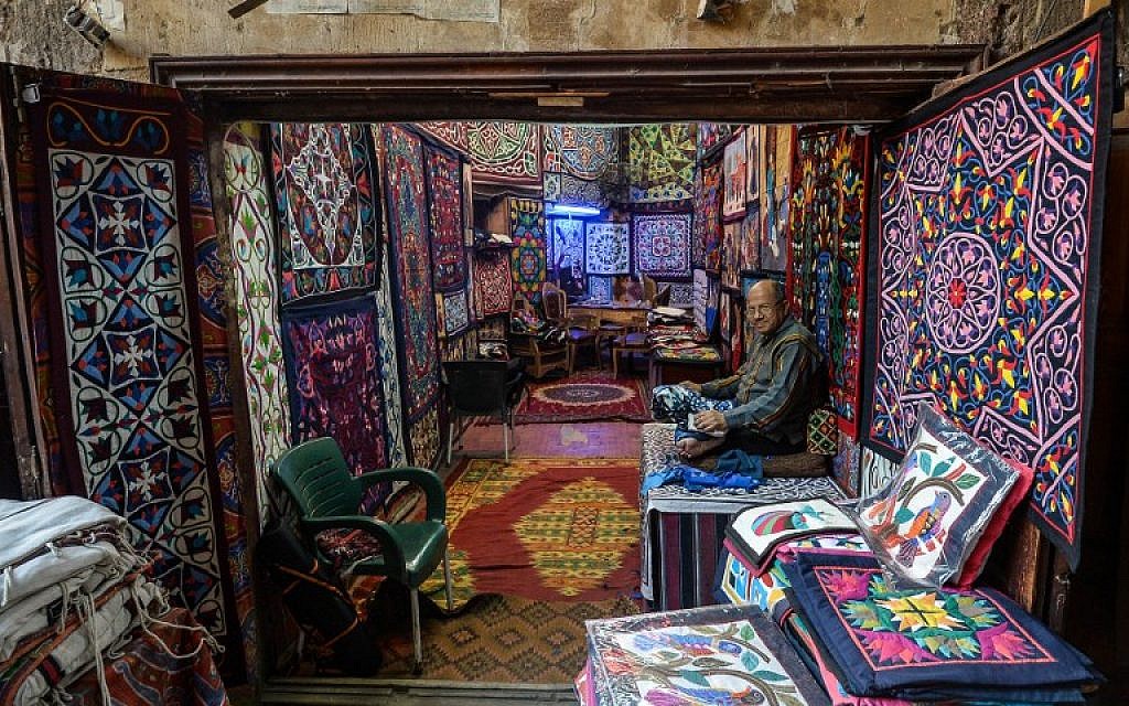 Un artisan égyptien travaille sur ses tapisseries, dans la rue Al-Khayamiya, au Caire, le 18 décembre 2019. (Crédit : Mohamed el-Shahed / AFP)