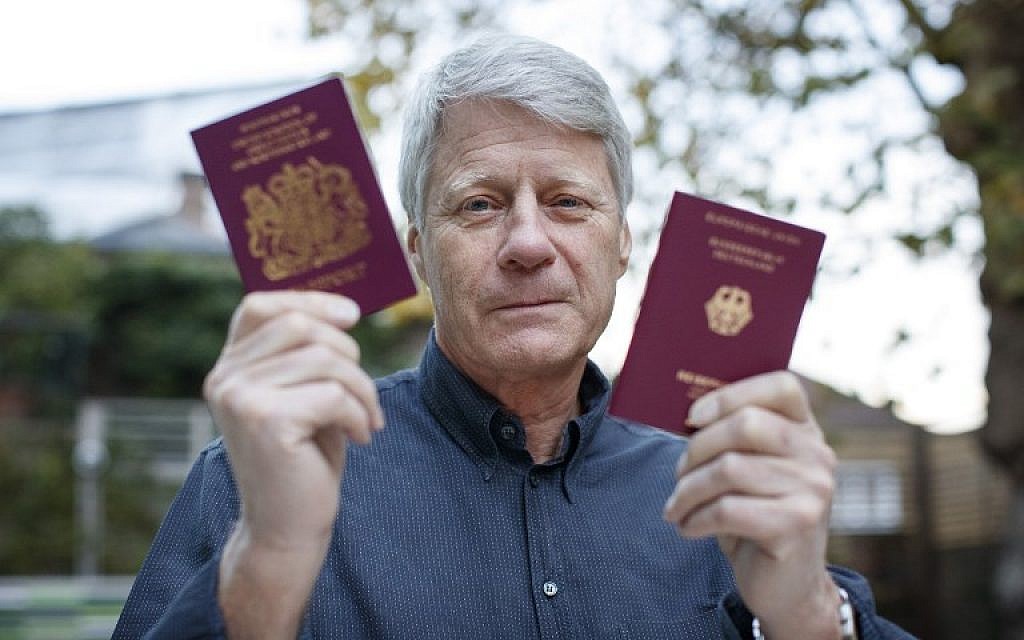 L'animateur TV Nick Ross avec son passeport allemand et son passeport britannique, le 5 novembre 2018. (Crédit : TOLGA AKMEN / AFP)