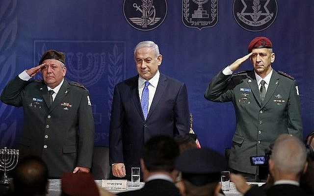 Le chef d'Etat-major sortant Gadi Eizenkot, à gauche, le Premier ministre Benjamin Netanyahu et le nouveau chef d'Etat-major Aviv Kochavi, à droite, lors de la cérémonie d'investiture de ce dernier au siège du ministère de la Défense de Tel Aviv, le 15 janvier 2019 (Crédit : JACK GUEZ/AFP) Le chef d'Etat-major sortant Gadi Eizenkot, à gauche, le Premier ministre Benjamin Netanyahu et le nouveau chef d'Etat-major Aviv Kochavi, à droite, lors de la cérémonie d'investiture de ce dernier au siège du ministère de la Défense de Tel Aviv, le 15 janvier 2019 (Crédit : JACK GUEZ/AFP)
