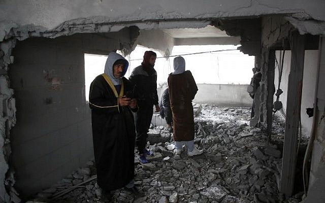 Des Palestiniens inspectent la maison d'un homme accusé d'avoir poignardé à mort en septembre un Israélien d'origine américaine, après sa démolition partielle par les forces israéliennes le 18 janvier 2019, dans le village de Yatta en Cisjordanie (HAZEM BADER / AFP)