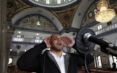Le bodybuilder arabe israélien et muezzin en chef Ibrahim Masri, appelle à la prière dans la mosquée d'el-Jazza, à Acre, le 29 janvier 2019. (Crédit : AHMAD GHARABLI / AFP)