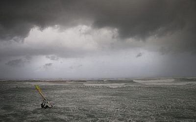 Un véliplanchiste surfe sur les vagues de la mer Méditerranée à Tel Aviv le 16 janvier 2019. (AP Photo/Oded Balilty)