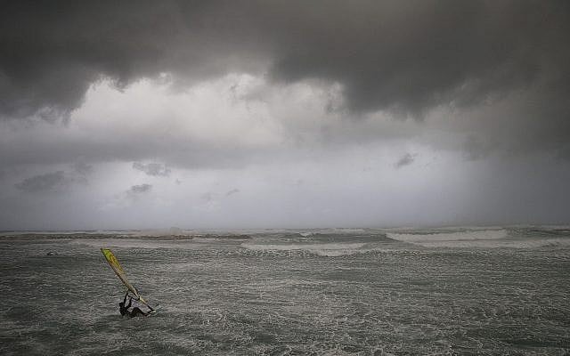 Un véliplanchiste surfe sur les vagues de la mer Méditerranée à Tel Aviv le 16 janvier 2019. (AP Photo/Oded Balilty)