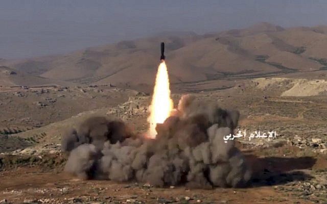 Capture d'écran d'une vidéo diffusée le 22 juillet 2017 et fournie par la presse militaire centrale syrienne contrôlée par le gouvernement, montre des combattants du Hezbollah tirant un missile sur des positions de militants liés à Al-Qaida dans une zone située à la frontière entre le Liban et la Syrie. (Presse militaire centrale syrienne, via AP)