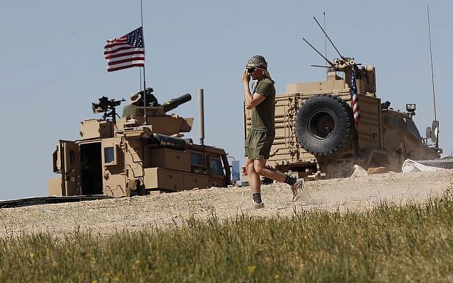 Un soldat américain se déplace sur une position nouvellement installée, près de la ligne de front tendue entre le Conseil militaire syrien de Manbij soutenu par les États-Unis et les combattants soutenus par la Turquie, à Manbij, au nord de la Syrie, le 4 avril 2018. (AP/Hussein Malla) Un soldat américain se déplace sur une position nouvellement installée, près de la ligne de front tendue entre le Conseil militaire syrien de Manbij soutenu par les États-Unis et les combattants soutenus par la Turquie, à Manbij, au nord de la Syrie, le 4 avril 2018. (AP/Hussein Malla)