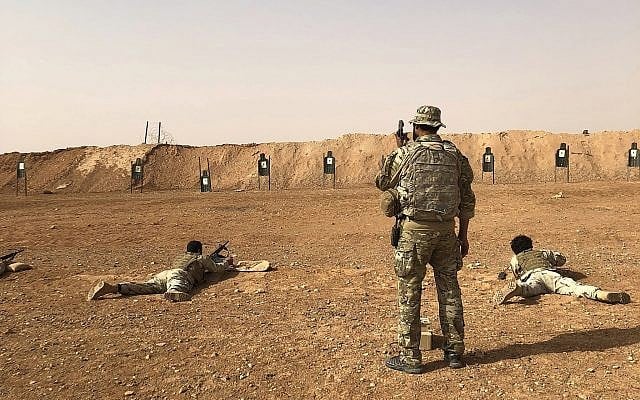 Les membres du groupe d'opposition syrien Maghawir al-Thawra reçoivent un entraînement aux armes des soldats des forces spéciales américaines à la base militaire al-Tanf en Syrie, le 22 octobre 2018 (Crédit : AP/Lolita Baldor) Les membres du groupe d'opposition syrien Maghawir al-Thawra reçoivent un entraînement aux armes des soldats des forces spéciales américaines à la base militaire al-Tanf en Syrie, le 22 octobre 2018 (Crédit : AP/Lolita Baldor)