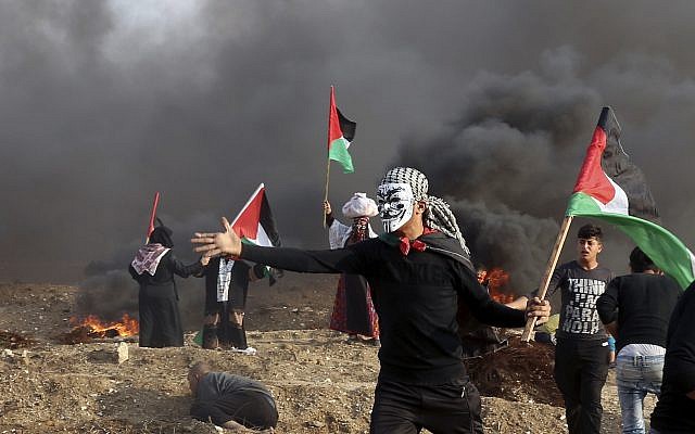 Des Palestiniens agitent leurs drapeaux nationaux tandis que d'autres brûlent des pneus près de la clôture de la frontière de la bande de Gaza avec Israël lors d'affrontements à l'est de la ville de Gaza, le 9 novembre 2018. (AP Photo/Adel Hana) Des Palestiniens agitent leurs drapeaux nationaux tandis que d'autres brûlent des pneus près de la clôture de la frontière de la bande de Gaza avec Israël lors d'affrontements à l'est de la ville de Gaza, le 9 novembre 2018. (AP Photo/Adel Hana)