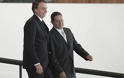 Le président brésilien Jair Bolsonaro, à gauche, se rend avec son vice-président Hamilton Mourao à une cérémonie au cours de laquelle les présidents des banques d'État du pays seront présentés au palais présidentiel Planalto de Brasilia, au Brésil, le lundi 7 janvier 2019. (Crédit : AP / Eraldo Peres) Le président brésilien Jair Bolsonaro, à gauche, se rend avec son vice-président Hamilton Mourao à une cérémonie au cours de laquelle les présidents des banques d'État du pays seront présentés au palais présidentiel Planalto de Brasilia, au Brésil, le lundi 7 janvier 2019. (Crédit : AP / Eraldo Peres)