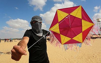 Un émeutier palestinien montre un cerf-volant chargé d'un engin incendiaire avant de le lancer vers Israël, à l'est de Rafah dans le sud de la bande de Gaza, le 29 juin 2018. (Crédit : Abed Rahim Khatib/Flash90) Un émeutier palestinien montre un cerf-volant chargé d'un engin incendiaire avant de le lancer vers Israël, à l'est de Rafah dans le sud de la bande de Gaza, le 29 juin 2018. (Crédit : Abed Rahim Khatib/Flash90)