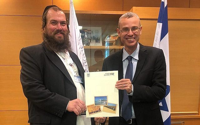 Yechiel Charaz (G) recevant un certificat lui permettant d'accueillir des visites guidées en langue yiddish des mains du ministre du Tourisme Yariv Levin à Jérusalem, le 13 janvier 2019. (Ministère du Tourisme)