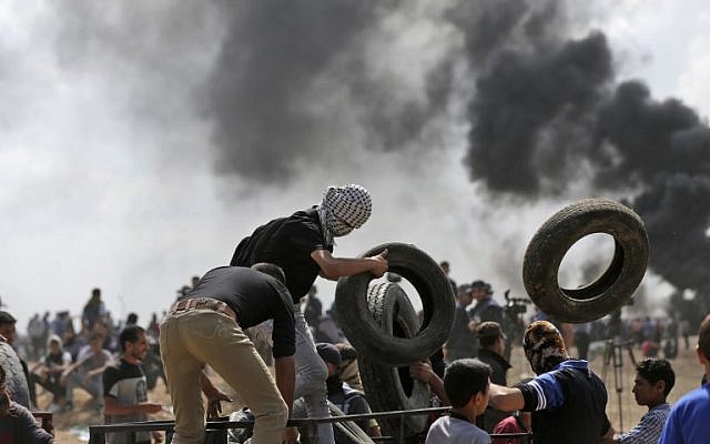 Des manifestants palestiniens brûlent des pneus près de la frontière entre Gaza et Israël, à l'est de la ville de Gaza, lors de manifestations contre l'inauguration de l'ambassade des États-Unis à Jérusalem, le 14 mai 2018. (AFP Photo/Mahmud Hams)