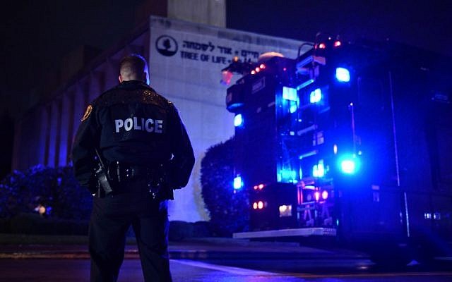 Un agent de police sous la pluie aux abords de la synagogue Tree of Life après une fusillade qui a fait onze morts dans le quartier de Squirrel Hill à Pittsburgh le 27 octobre 2018 (Crédit : Brendan Smialowski / AFP) Un agent de police sous la pluie aux abords de la synagogue Tree of Life après une fusillade qui a fait onze morts dans le quartier de Squirrel Hill à Pittsburgh le 27 octobre 2018 (Crédit : Brendan Smialowski / AFP)