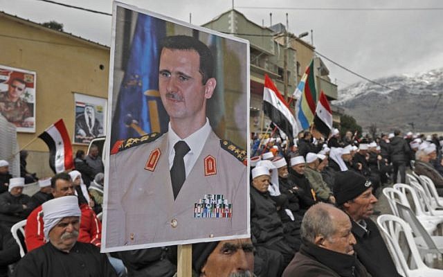 Des résidents druzes du plateau du Golan portent un portrait du président syrien Bashar al-Assad pendant un rassemblement dans le village de Majdal Shams, le 14 février 2019 (Crédit : JALAA MAREY / AFP) Des résidents druzes du plateau du Golan portent un portrait du président syrien Bashar al-Assad pendant un rassemblement dans le village de Majdal Shams, le 14 février 2019 (Crédit : JALAA MAREY / AFP)