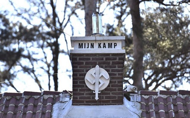 Une photo prise à Keerbergen, dans le nord de la Belgique le 15 février 2019 montre une swastika sur laquelle on peut lire 'Mijn Kamp' ("Mein Kampf" en flamand) sur la cheminée de la maison décorée d'autres symboles nazis (Crédit: DIRK WAEM / BELGA / AFP)
