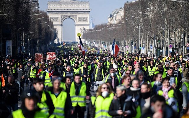 Des manifestants défilent sur l'avenue des Champs-Élysées le 16 février 2019, lors de la 14e semaine consécutive de manifestations des "Gilets jaunes". (Crédit : Eric Feferberg/AFP) Des manifestants défilent sur l'avenue des Champs-Élysées le 16 février 2019, lors de la 14e semaine consécutive de manifestations des "Gilets jaunes". (Crédit : Eric Feferberg/AFP)
