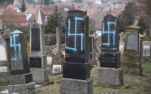 Une photo prise le 20 février 2019 à Quatzenheim montre des svastikas peintes sur des tombes dans un cimetière juif, le jour d'une marche nationale contre une recrudescence des attaques antisémites. - Environ 96 tombes ont été vandalisées dans un cimetière du village de Quatzenheim, près de la frontière avec l'Allemagne, dans la région Alsace. (Crédit : Frederick FLORIN / AFP) Une photo prise le 20 février 2019 à Quatzenheim montre des svastikas peintes sur des tombes dans un cimetière juif, le jour d'une marche nationale contre une recrudescence des attaques antisémites. - Environ 96 tombes ont été vandalisées dans un cimetière du village de Quatzenheim, près de la frontière avec l'Allemagne, dans la région Alsace. (Crédit : Frederick FLORIN / AFP)