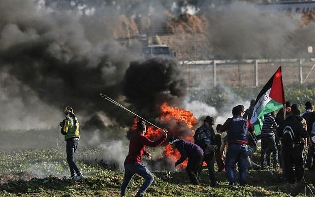 Des émeutiers palestiniens brûlent des pneus lors d’une manifestation à proximité de la frontière le long de la frontière avec Israël, à l’est de la bande de Gaza, le 22 février 2019. (Crédit : MAHMUD HAMS / AFP) Des émeutiers palestiniens brûlent des pneus lors d’une manifestation à proximité de la frontière le long de la frontière avec Israël, à l’est de la bande de Gaza, le 22 février 2019. (Crédit : MAHMUD HAMS / AFP)