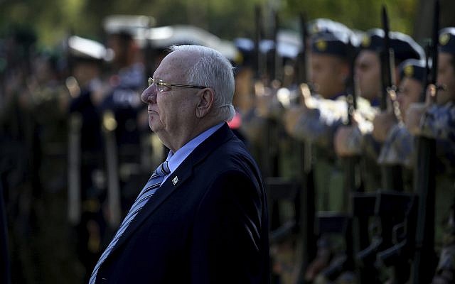 Le président Reuven Rivlin passe en revu la garde d'honneur durant une cérémonie à Chypre, le 12 février 2019. (Crédit : AP/Petros Karadjias)