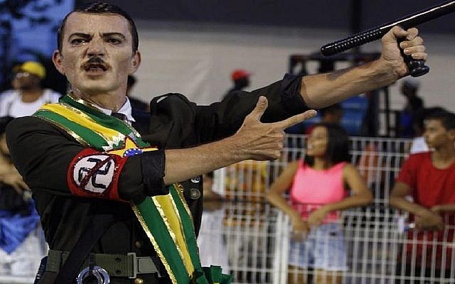 Un danseur d'une école de samba brésilienne lors de répétitions du Carnaval fait l'amalgame entre Adolf Hitler et Jair Bolsonaro, le nouveau président brésilien. (Crédit : Ismael Toledo via JTA)