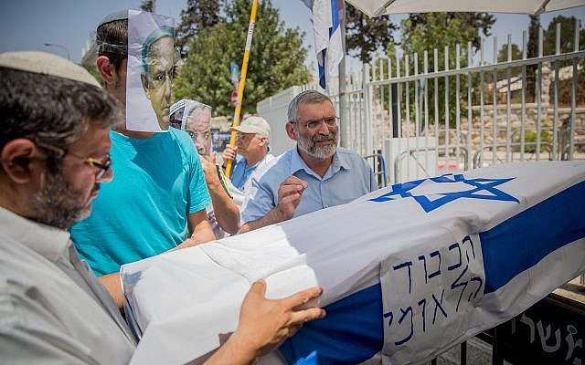 Itamar Ben Gvir (à gauche) et Michael Ben-Ari (à droite), candidats de Otzma Yehudit, portent un faux cercueil avec un homme portant un masque de Benjamin Netanyahu lors d'une manifestation à Jérusalem le 27 juillet 2017. (Yonatan Sindel/Flash90) Itamar Ben Gvir (à gauche) et Michael Ben-Ari (à droite), candidats de Otzma Yehudit, portent un faux cercueil avec un homme portant un masque de Benjamin Netanyahu lors d'une manifestation à Jérusalem le 27 juillet 2017. (Yonatan Sindel/Flash90)