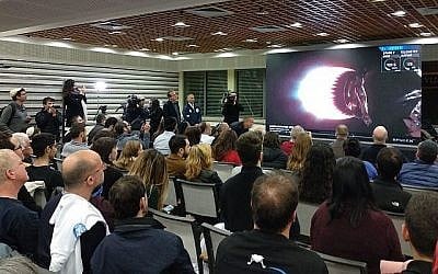 Des centaines d'ingénieurs et leurs familles réunis à la cafétéria des industries aérospatiales israéliennes à Yehud regardent le lancement en direct de la sonde Beresheet, le 22 février 2019 (Crédit : Melanie Lidman/Times of Israel)