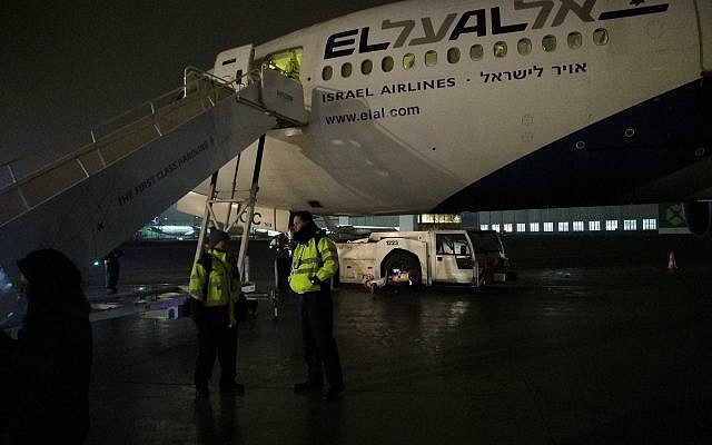 Des membres d'équipage se tiennent au pied de l'avion endommagé du Premier ministre Benjamin Netanyahu. (Crédit : Raphael Ahren/Times of Israel) Des membres d'équipage se tiennent au pied de l'avion endommagé du Premier ministre Benjamin Netanyahu. (Crédit : Raphael Ahren/Times of Israel)