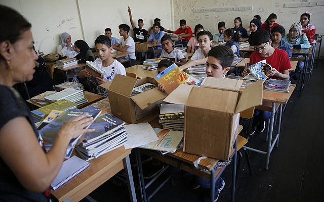 Des écoliers palestiniens reçoivent de nouveaux manuels dans leur classe lors de la rentrée de cette année dans l’une des écoles de l’UNRWA à Beyrouth au Liban, le 3 septembre 2018. (Hussein Malla/AP) Des écoliers palestiniens reçoivent de nouveaux manuels dans leur classe lors de la rentrée de cette année dans l’une des écoles de l’UNRWA à Beyrouth au Liban, le 3 septembre 2018. (Hussein Malla/AP)