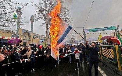 Des Iraniens brûlent des drapeaux israéliens lors de commémorations du 40e anniversaire de la République islamique dans la capitale Téhéran le 11 février 2019. (Atta Kenare/AFP)