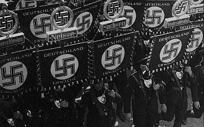 Des membres SS portent des drapeaux avec une croix gammées et des noms des régions et des villes allemandes alors qu'il marchent vers la mairie de Nuremberg, en Allemagne, le 10 septembre 1935, pour ouvrir la convention du Parti des Travailleurs d'Allemagne Nationale Socialiste (AP Photo). Des membres SS portent des drapeaux avec une croix gammées et des noms des régions et des villes allemandes alors qu'il marchent vers la mairie de Nuremberg, en Allemagne, le 10 septembre 1935, pour ouvrir la convention du Parti des Travailleurs d'Allemagne Nationale Socialiste (AP Photo).
