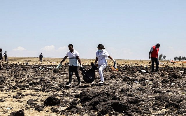 Des équipes de secouristes transportent des sacs mortuaires sur le lieu du crash du Boeing d'Ethiopian Airlines, le 10 mars 2019. (Crédit : Michael TEWELDE / AFP)