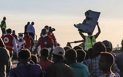 Un homme porte un débris d'avion sur le lieu du crash du Boeing d'Ethiopian Airlines, le 12 mars 2019. (Crédit : Michael TEWELDE / AFP))