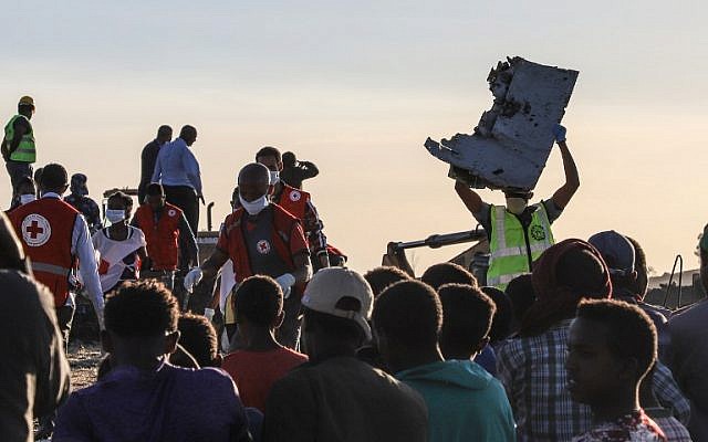 Un homme porte un débris d'avion sur le lieu du crash du Boeing d'Ethiopian Airlines, le 12 mars 2019. (Crédit : Michael TEWELDE / AFP))