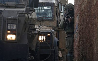 Un soldat israélien monte la garde  pendant une opération de recherche d'un suspect palestinien dans le village de Salem,dans le nord de la Cisjordanie et à l'est de Naplouse, le 18 mars 2019 (Crédit : JAAFAR ASHTIYEH / AFP)
