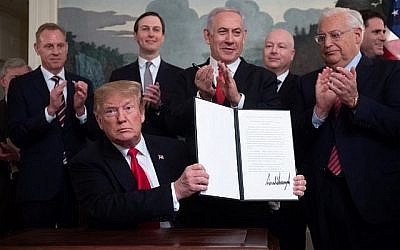 Le président américain Donald Trump présente un décret signé reconnaissant la souveraineté d'Israël sur le plateau du Golan, sous le regard du Premier ministre Benjamin Netanyahu dans la salle de réception diplomatique de la Maison Blanche à Washington, le 25 mars 2019. (Saul Loeb/AFP)