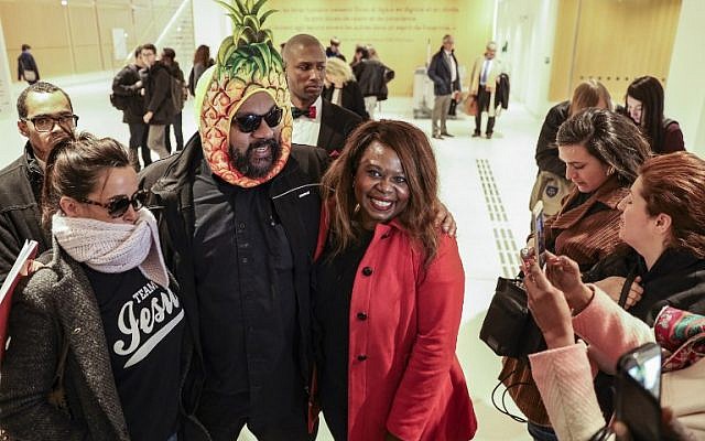 Dieudonné M'bala M'bala, portant un masque représentant un ananas en référence à son expression négationniste 'shoahananas', pose à son arrivée au palais de justice de Paris le 26 mars 2019, (Crédit : KENZO TRIBOUILLARD / AFP) Dieudonné M'bala M'bala, portant un masque représentant un ananas en référence à son expression négationniste 'shoahananas', pose à son arrivée au palais de justice de Paris le 26 mars 2019, (Crédit : KENZO TRIBOUILLARD / AFP)