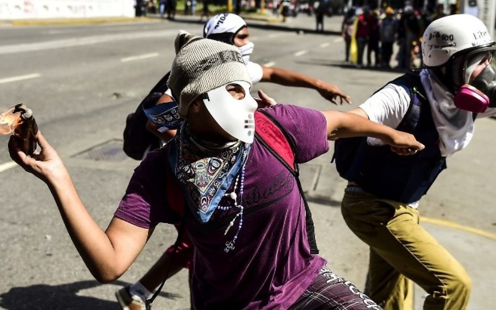 Un militant de l'opposition lance un cocktail Molotov lors d'affrontements avec les forces de sécurité dans la capitale vénézuélienne de Caracas, le 12 août 2017. (AFP Photo/Ronaldo Schemidt)