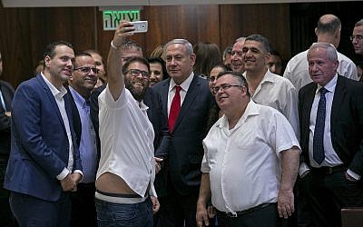 Le député Likud Oren Hazan prend un selfie avec le Premier ministre Benjamin Netanyahu, (au centre), et le député David Bitan, (à droite de Netanyahu), après l'adoption de la loi de l'État-nation à la Knesset, le 19 juillet 2018. (AP Photo/Olivier Fitoussi) Le député Likud Oren Hazan prend un selfie avec le Premier ministre Benjamin Netanyahu, (au centre), et le député David Bitan, (à droite de Netanyahu), après l'adoption de la loi de l'État-nation à la Knesset, le 19 juillet 2018. (AP Photo/Olivier Fitoussi)