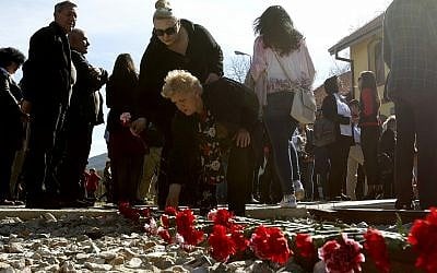 Des fleurs sont posées sur les rails au cours d'une cérémonie de commémoration des victimes de la Shoah à la gare de Bitola, dans le sud de la Macédoine, le 11 mars 2019 (Crédit : AP Photo/Boris Grdanoski)