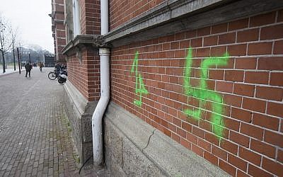 Une croix gammée taguée dans la nuit sur le mur du musée Stedelijk à Amsterdam, le 22 février 2019 (Crédit : AP Photo/Peter Dejong)