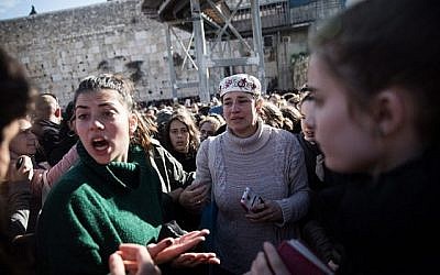Les membres du groupe des Femmes du mur lors des prières de Rosh Hodesh  alors que des milliers d'ultra-orthodoxes manifestent contre elles au mur occidental, dans la Vieille Ville de Jérusalem, le 8 mars 2019 (Crédit : Hadas Parush/Flash90)