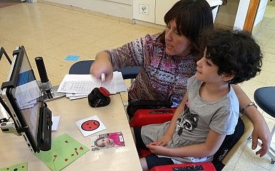 Ayala, 11 ans, une élève atteinte d'un trouble cognitif, communique via un écran d'ordinateur avec son enseignante, Rivka Dimant, dans une école d'Aleh Negev, un campus pour Israéliens souffrant de handicaps, le 25 octobre 2018. (Crédit : Ben Sales via JTA)