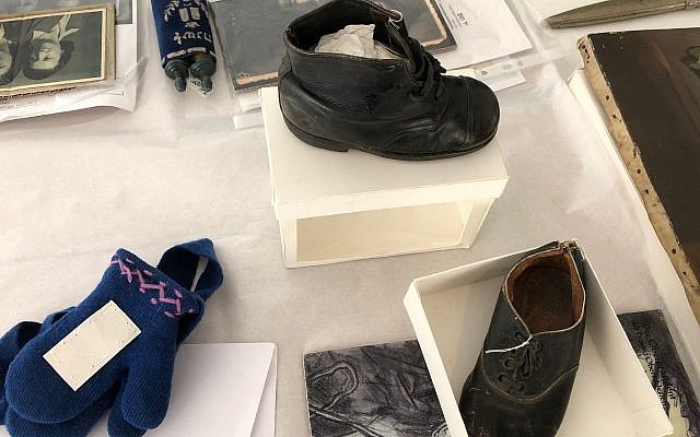 Une chaussure et des gants ayant appartenu à Hinda Cohen, deux ans, tuée à  Auschwitz le 27 mars 1944. Son père Dov avait écrit la date en découvrant que sa fillette avait été raflée durant une 'Aktion Enfants". (Crédit : Amanda Borschel-Dan/Times of Israel)