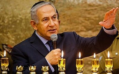 Le Premier ministre Benjamin Netanyahu, à gauche, s'exprime pendant une cérémonie d'allumage de bougies à l'occasion de la fête de Hanoukkah, au mur Occidental, dans la Vieille ville de Jérusalem, le 6 décembre 2018 (Crédit : Gil Cohen-Magen/Pool/AFP)
